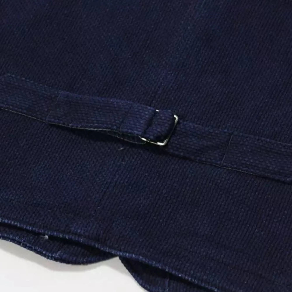 Ce gilet sans manche Indigo Sashiko est pratique et élégant. Grâce a sa coupe droite et grâce a ses ouvertures suffisamment large, vous pourrez le porter avec un sweat ou un pull en dessous. Il possède une martingale au dos pour pouvoir le resserrer comme on le souhaite. Ce gilet est pensé pour retenir la chaleur avec sa doublure en chambray.   100% coton tissu Indigo Sashiko tissu japonais