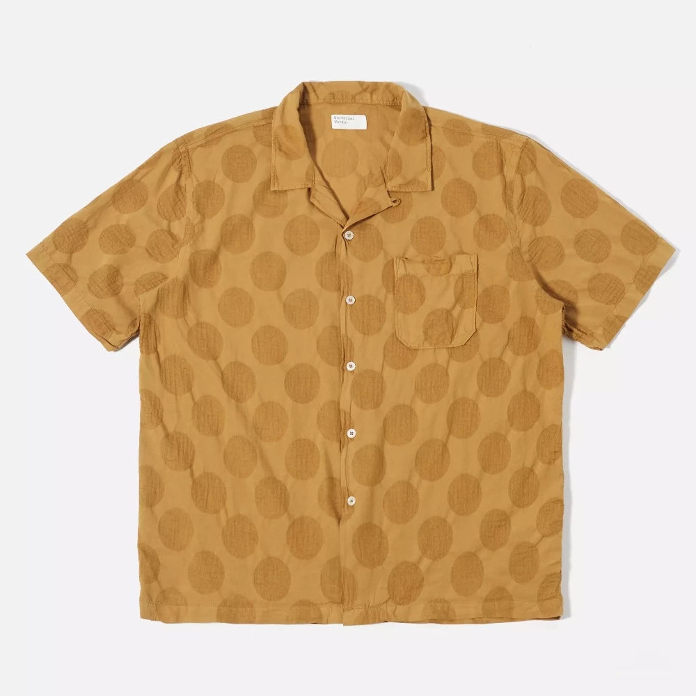 La chemise road shirt Universal Works possède un col cubain ou camp collar, idéal à porter en été. Sa couleur cumin et son imprimé apporterons une petite touche 70's.   100% lightweight coton