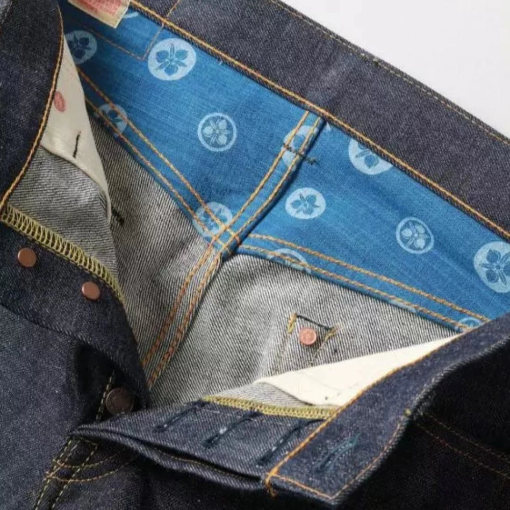 Le classique jeans Momotaro 0605 ici proposé dans la série 'copper label' avec une toile selvedge 'legacy blue' plus clair, rappelant les denims d'époque.  L'absence des bandes caractéristique et sa toile plus souple en font un jeans du quotidien simple à porter avec un joli potentiel de délavage.  La coupe est droite légèrement ajusté (similaire au j466 Japan blue)