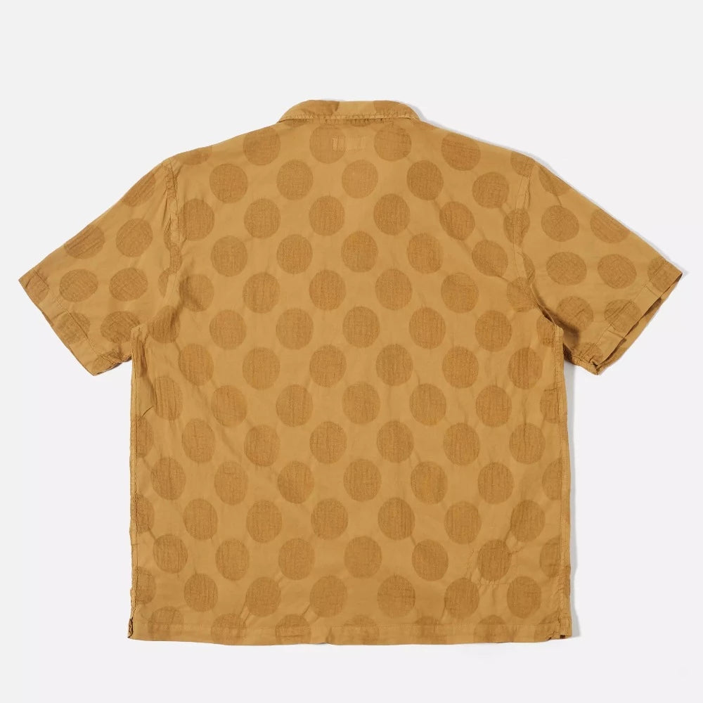 La chemise road shirt Universal Works possède un col cubain ou camp collar, idéal à porter en été. Sa couleur cumin et son imprimé apporterons une petite touche 70's.   100% lightweight coton