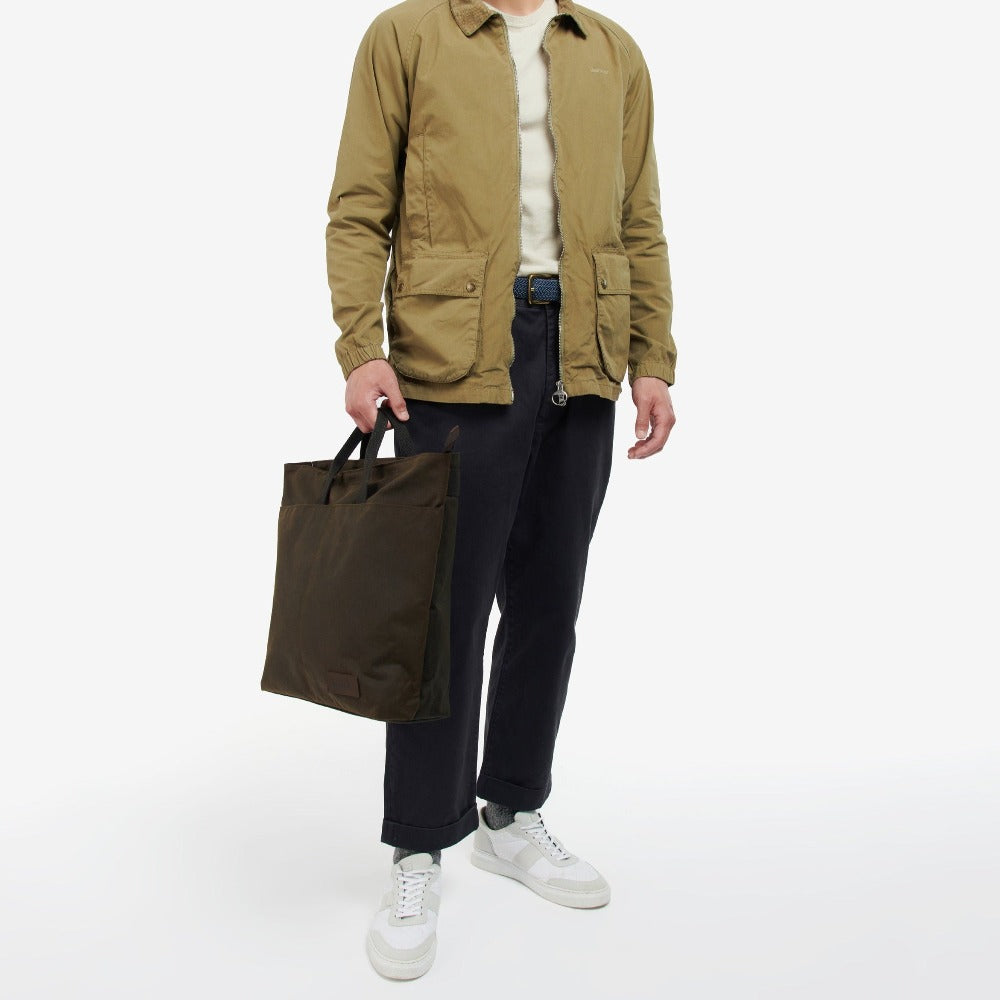 Le tote bag Barbour est inspiré des emblématiques vestes Barbour avec sa toile en coton ciré et son tartan à l'intérieur.   Il peut être porté en sac à dos ou à la main.
